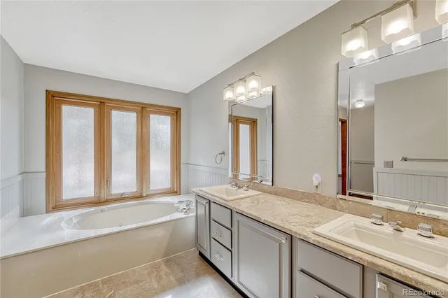 a bathroom with a granite countertop sink and a large mirror