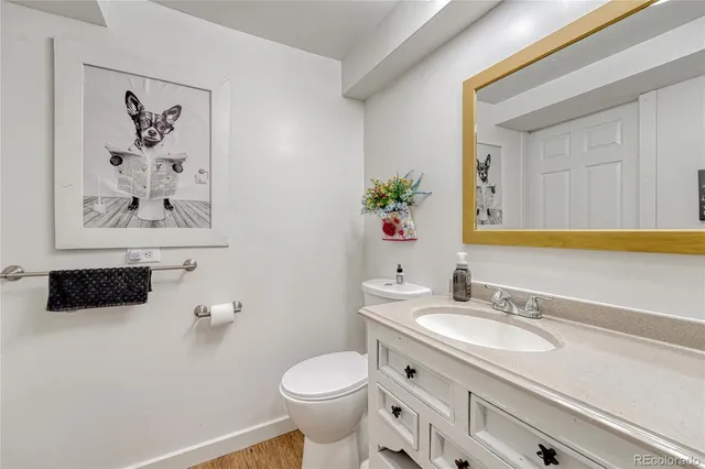 a bathroom with a granite countertop sink mirror and toilet
