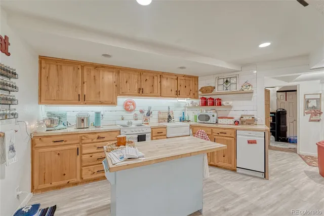 a kitchen with cabinets appliances and wooden floor