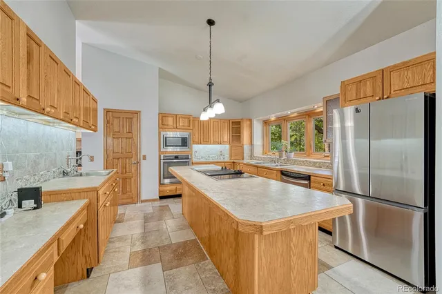 a kitchen with stainless steel appliances granite countertop a sink a stove and a refrigerator
