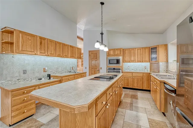 a kitchen with stainless steel appliances a sink a stove a refrigerator and cabinets