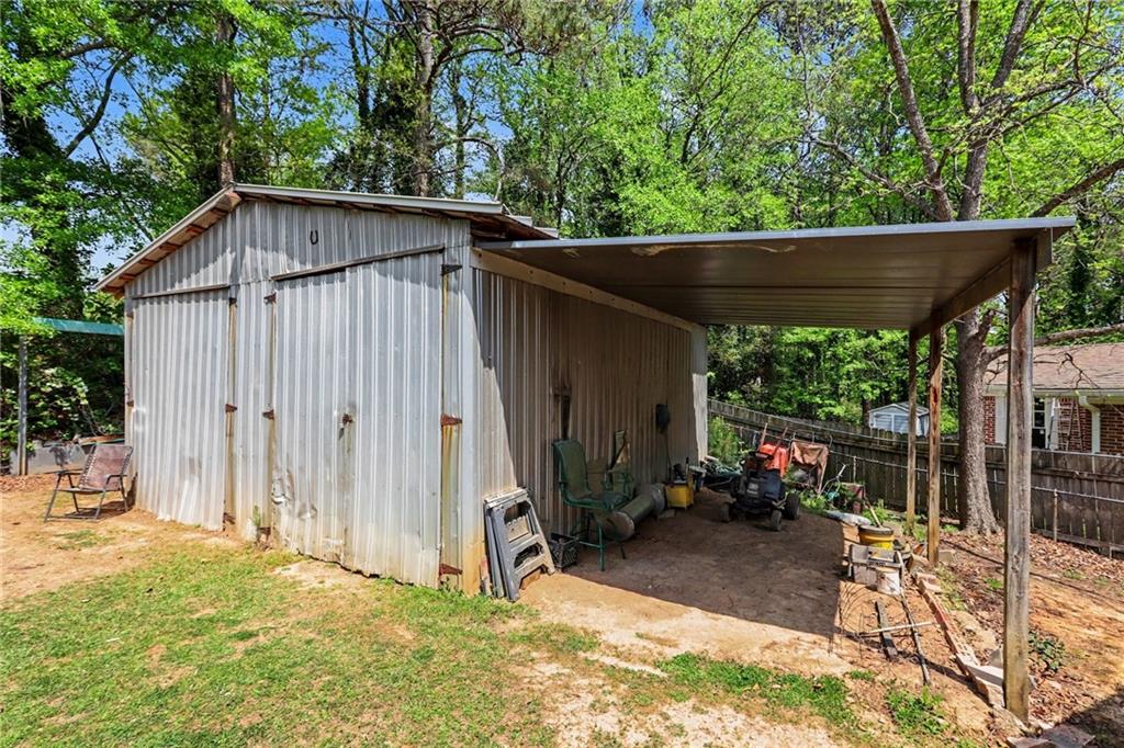 7019 Lake View Lane Doraville, GA 30360 - Photo 28 of 32 a backyard of a house with table and chairs under an umbrella