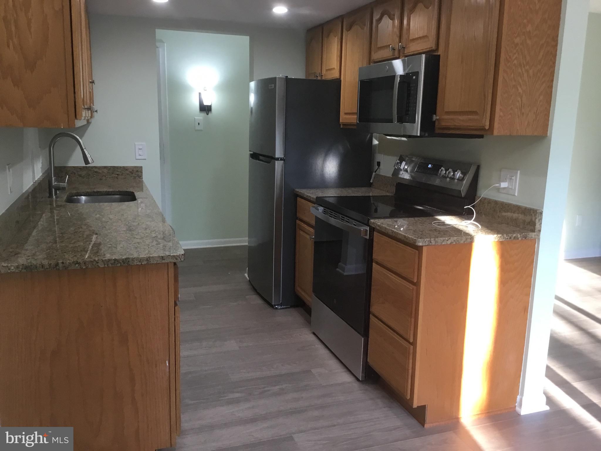 11609 Stoneview Square, Unit 11C Reston, VA 20191 - Photo 21 of 23 a kitchen with stainless steel appliances granite countertop a stove a refrigerator and a sink