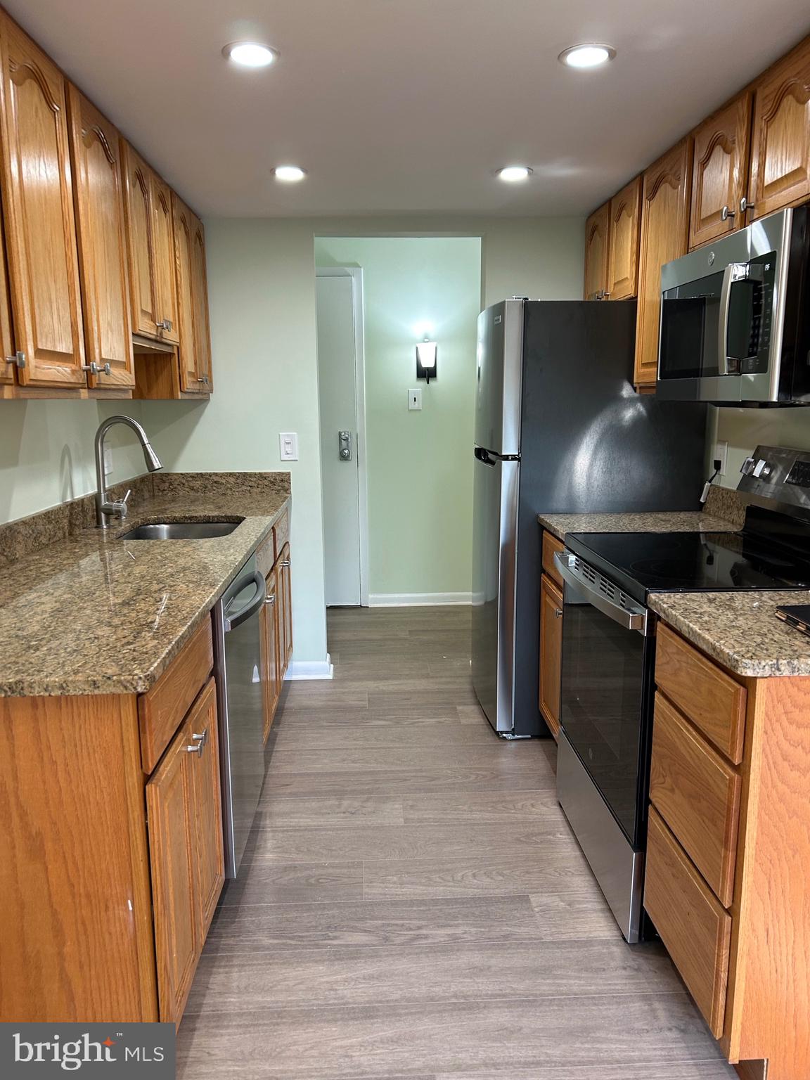 11609 Stoneview Square, Unit 11C Reston, VA 20191 - Photo 4 of 23 a kitchen with kitchen island granite countertop a sink stove and refrigerator