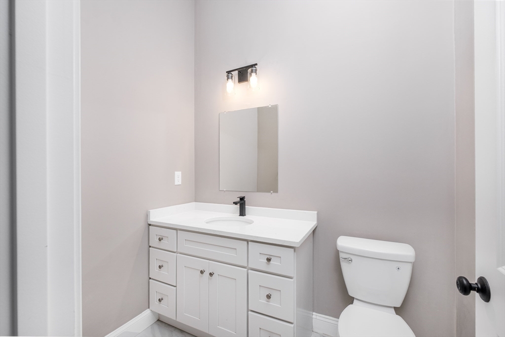 216 Vane Street, Unit 2 Revere, MA 02151 - Photo 6 of 22 a bathroom with a toilet sink and mirror