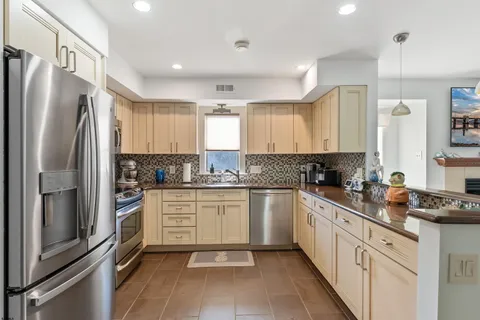 a kitchen with a refrigerator sink and cabinets