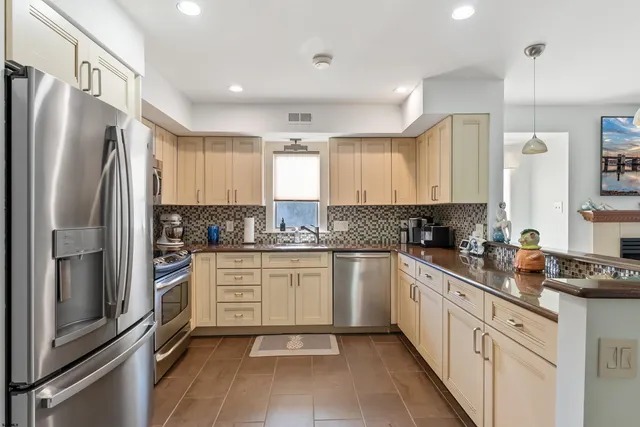 a kitchen with a refrigerator sink and cabinets