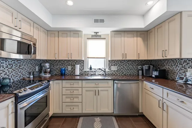 a kitchen with granite countertop white cabinets and white appliances