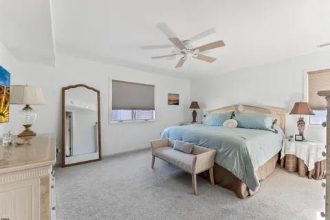 a spacious bedroom with a bed and a chandelier