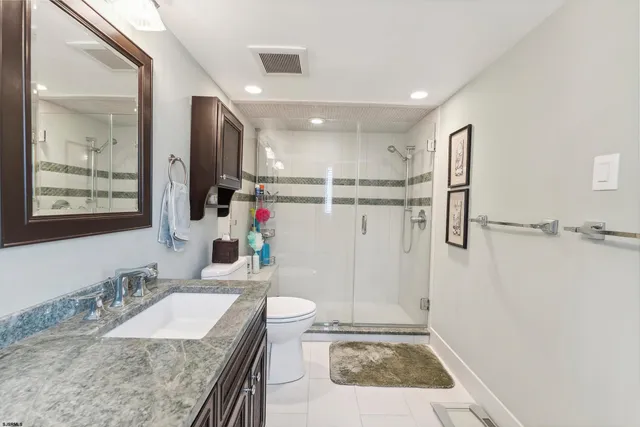 a bathroom with a granite countertop sink a mirror a shower and a shower