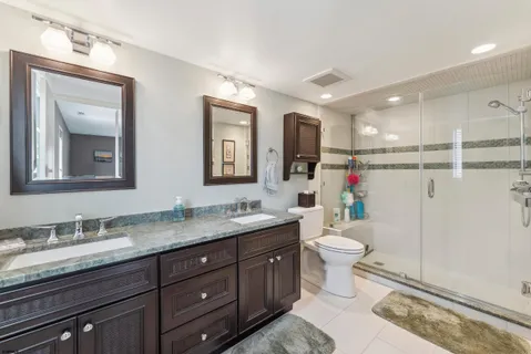 a bathroom with a granite countertop sink toilet and mirror