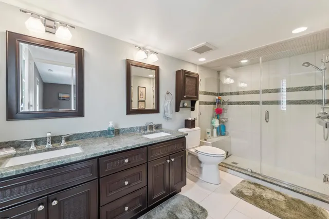 a bathroom with a granite countertop sink toilet and mirror