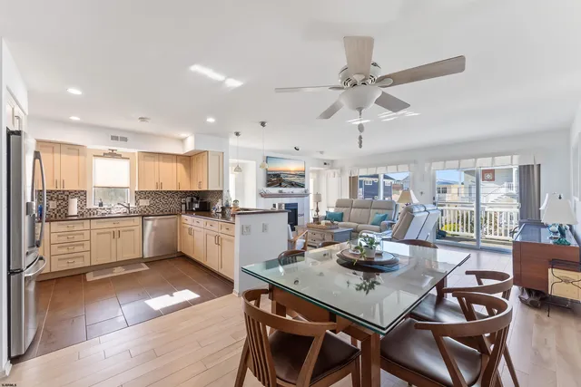 a kitchen with a dining table chairs stainless steel appliances and cabinets