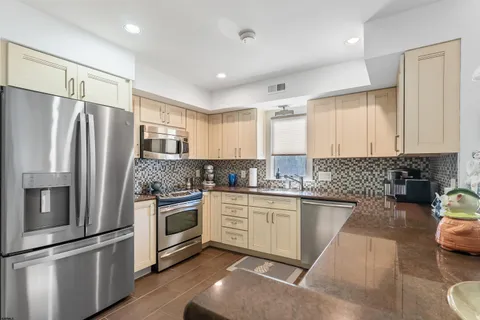 a kitchen with granite countertop stainless steel appliances and wooden cabinets