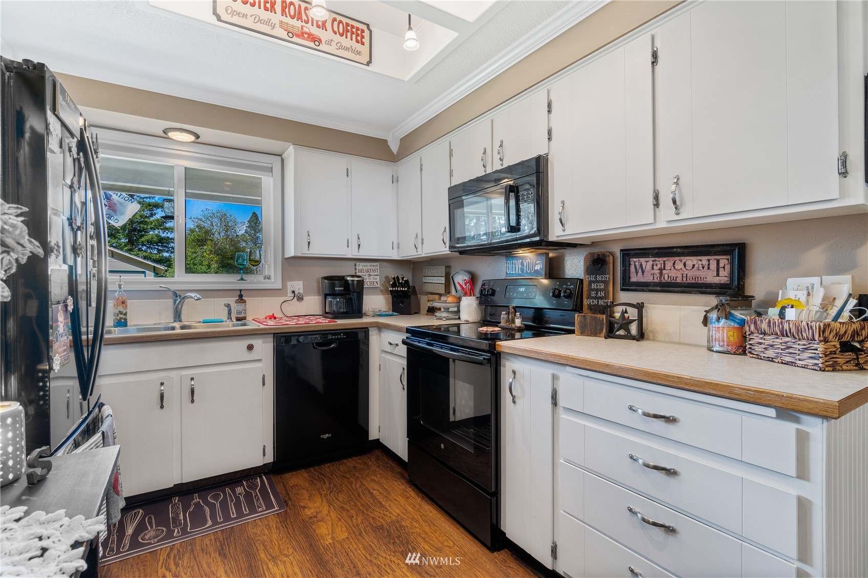 151 Fircrest Road Napavine, WA 98532 - Photo 4 of 28 a kitchen with white cabinets a sink dishwasher and a stove with wooden floor