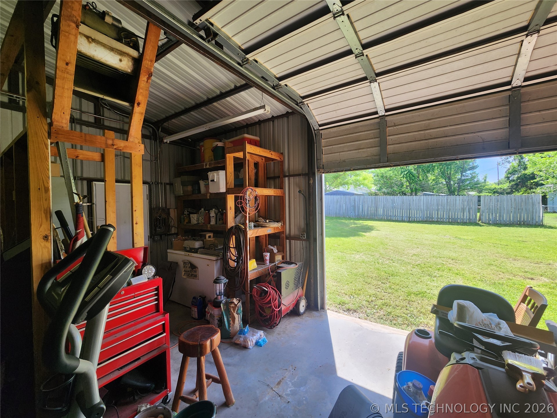 149 West Ruth Atoka, OK 74525 - Photo 59 of 62 Spacious utility building featuring a roll-up garage door, concrete flooring, and built-in shelving