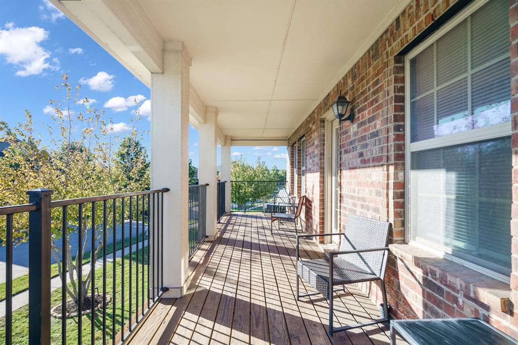 a view of a porch with wooden floor and iron fence
