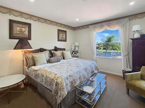 a spacious bedroom with a bed a couch and a large window