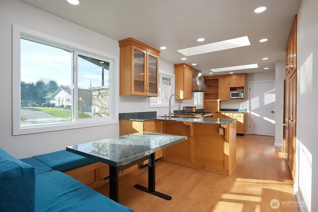 a living room with dining table furniture and a kitchen view