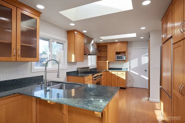 a large kitchen with granite countertop a large counter top stainless steel appliances and a counter top space