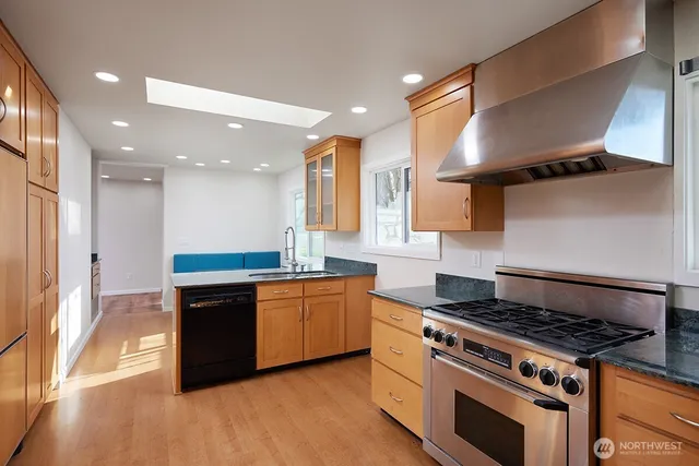 a kitchen with stainless steel appliances granite countertop a stove and a sink