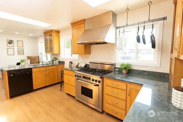 a kitchen with stainless steel appliances granite countertop a stove a sink and a refrigerator