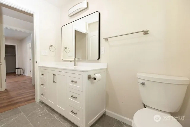 a bathroom with a toilet a sink a vanity and mirror