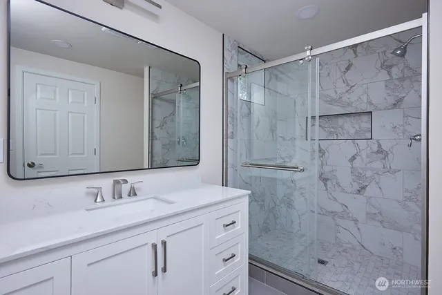 a bathroom with a shower sink and mirror