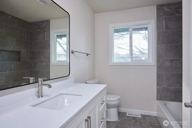 a bathroom with a sink toilet and window