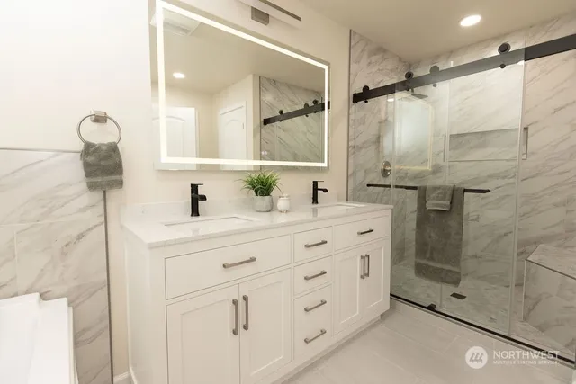 a bathroom with a double vanity sink mirror and shower