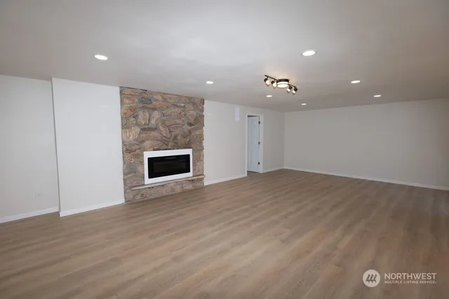 an empty room with wooden floor and a fireplace