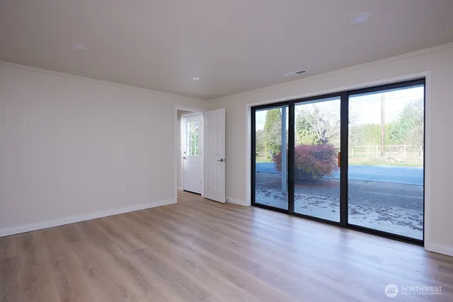 an empty room with wooden floor and door