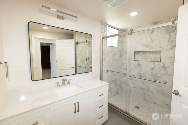 a bathroom with a shower sink and mirror