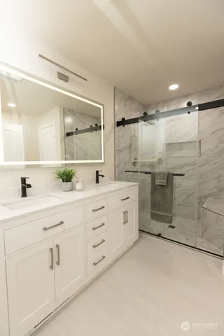 a bathroom with a shower sink and mirror
