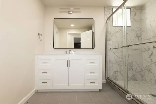 a bathroom with a bathtub sink vanity and mirror