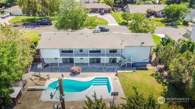an aerial view of a house with swimming pool and patio