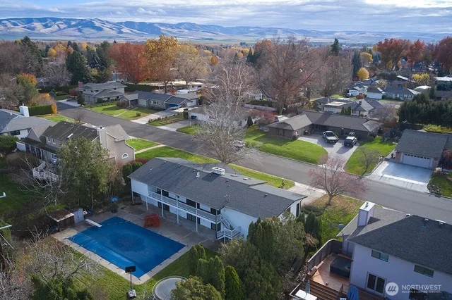 an aerial view of residential houses with outdoor space and street view