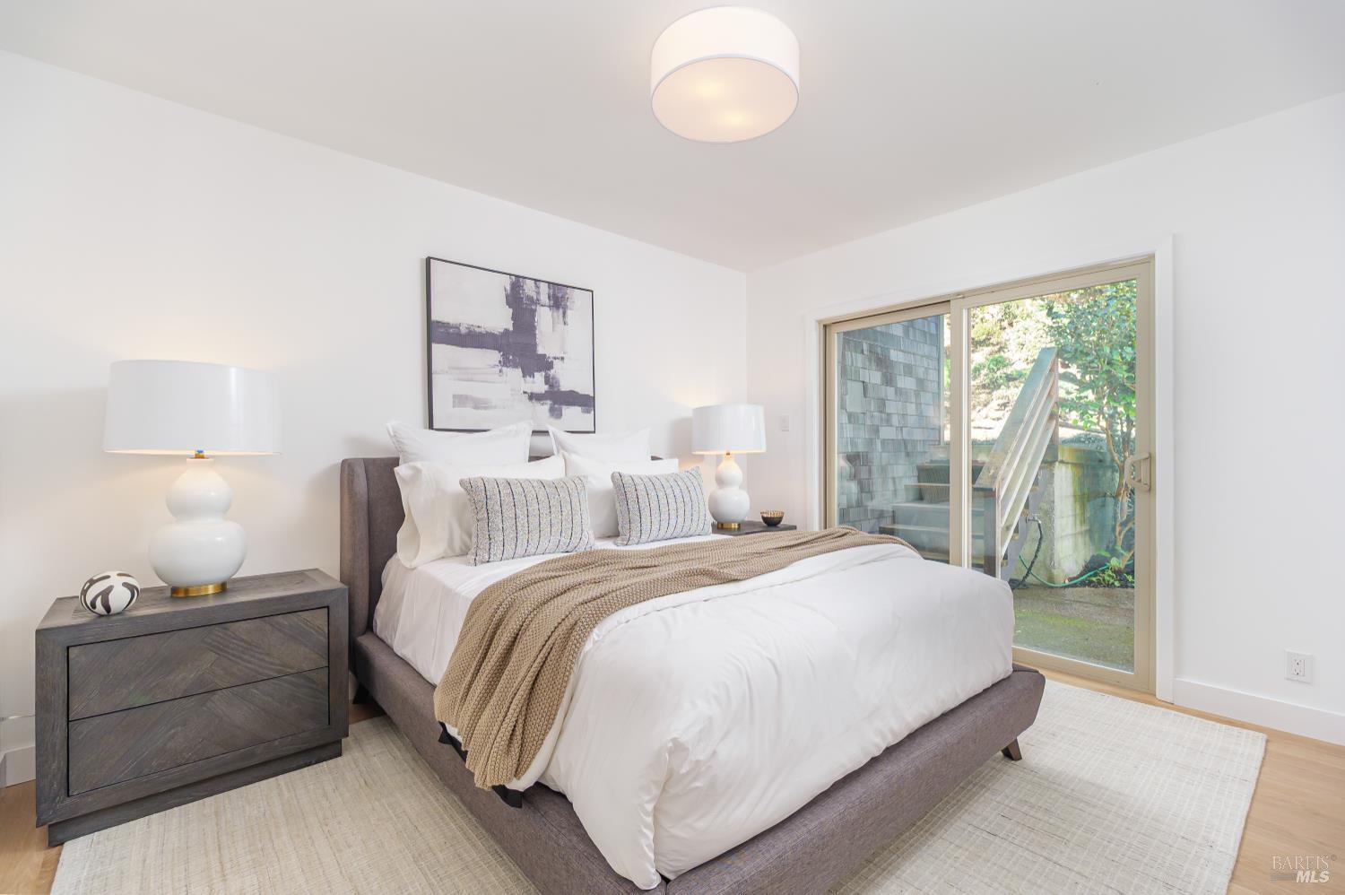 9 Underhill Road Mill Valley, CA 94941 - Photo 17 of 27 a bedroom with a large bed and a lamp next to a window