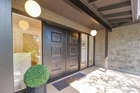 a living room with fireplace furniture and a large window
