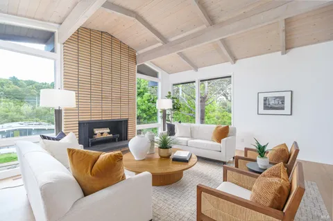 a living room with furniture a fireplace and a large window