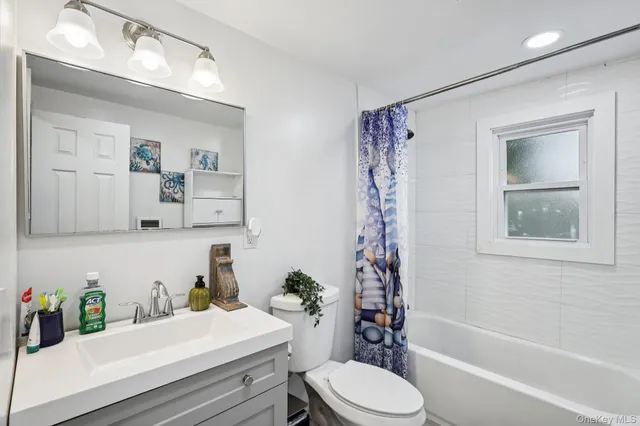 a bathroom with a toilet sink vanity and mirror