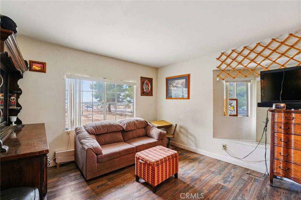 18947 Waseca Road Apple Valley, CA 92307 - Photo 11 of 34 a living room with furniture a flat screen tv and a wooden floor