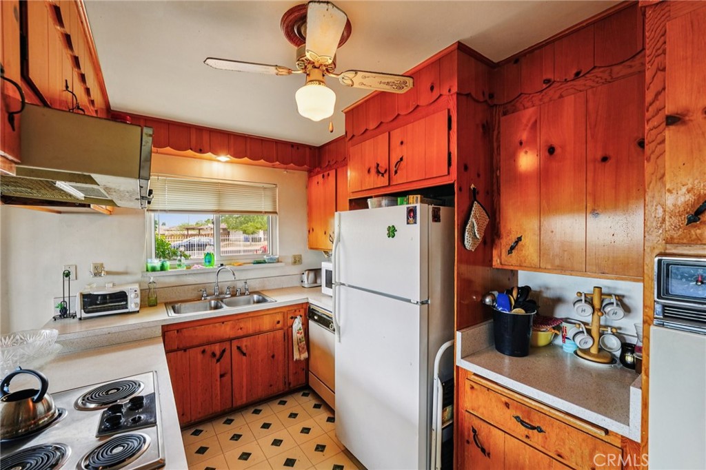 18947 Waseca Road Apple Valley, CA 92307 - Photo 4 of 34 a kitchen with a refrigerator and a stove top oven