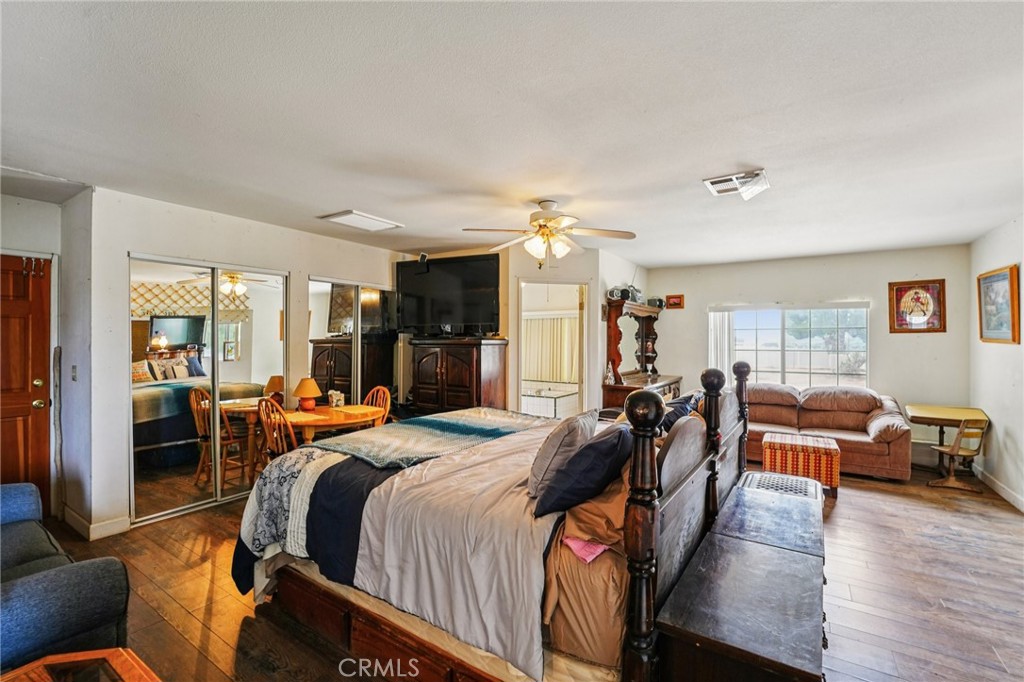 18947 Waseca Road Apple Valley, CA 92307 - Photo 10 of 34 a bedroom with furniture a wooden floor and a large window