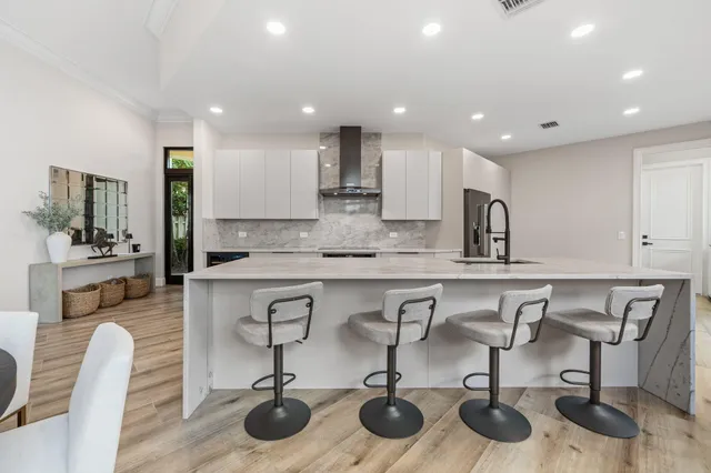 a kitchen with stainless steel appliances granite countertop a sink a stove and cabinets
