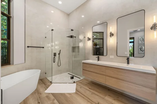 a bathroom with a large tub a sink a toilet and a shower