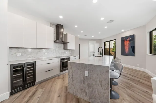 a large kitchen with granite countertop a stove top oven a sink a counter space and cabinets