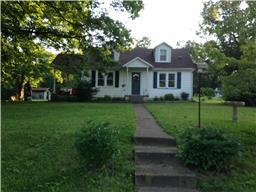 a front view of a house with yard and green space
