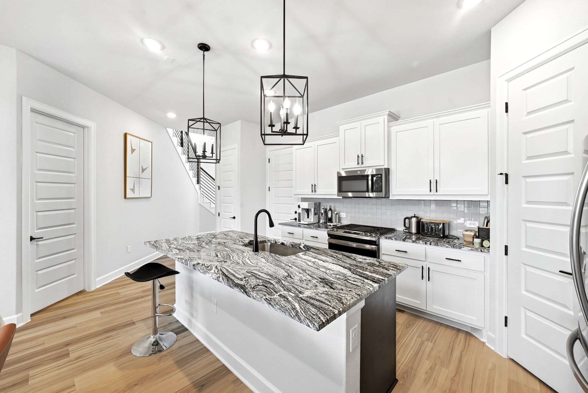 2702 Sebring Circle Austin, TX 78747 - Photo 10 of 35 Dramatic granite countertops elevate this contemporary culinary space anchored by a central island.