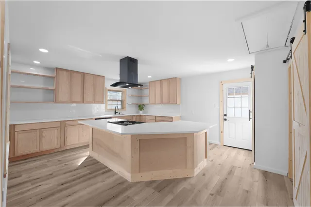 a kitchen with a stove and wooden floor